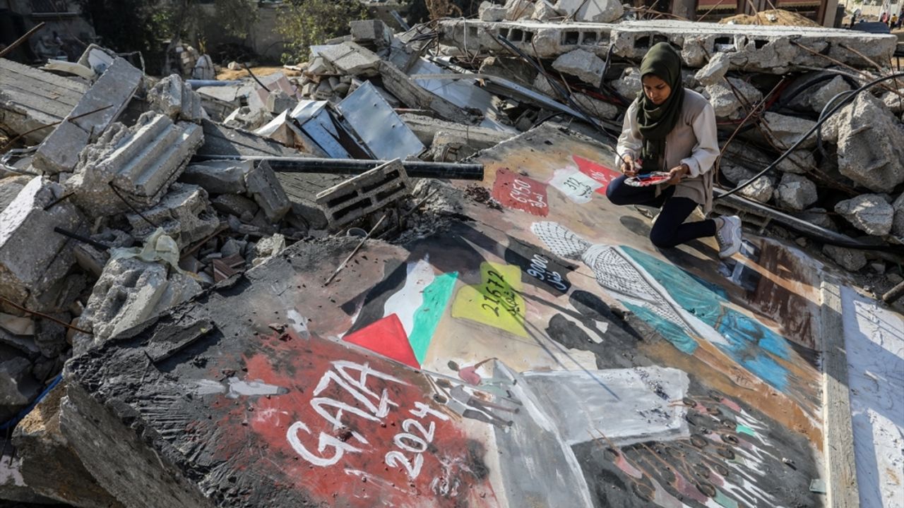 Gazze'de kadın sanatçı, "İsrail saldırılarının ağır bilançosunu" yıkıntıların üzerine resmetti